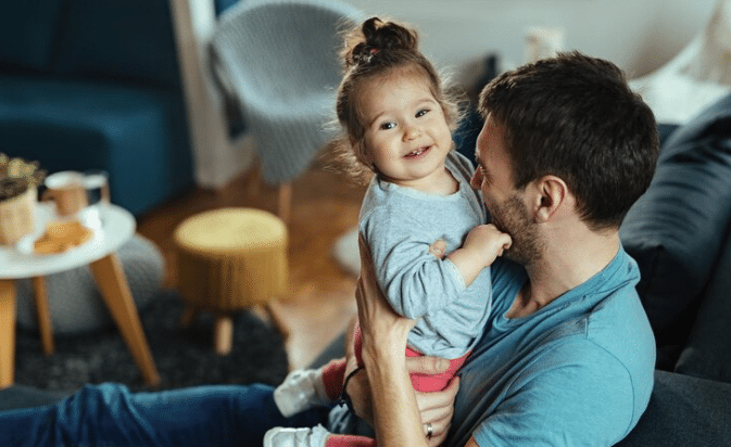 father and his small daughter having fun together at home