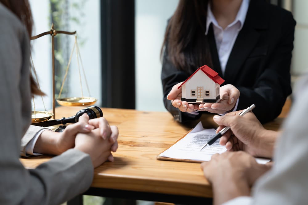 happy couple husband wife signing rental contract at meeting with realtor or landlord, first property purchase, mortgage and loan ownership concept.
